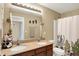 Charming bathroom with double vanity, granite countertop, and a shower with decorative curtains at 2504 Boylston Ct, Zionsville, IN 46077