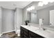 Bright bathroom with a dual sink vanity, a large mirror, and a shower with white marble-style tile at 3046 W New York St, Indianapolis, IN 46222