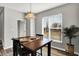 Bright dining area features dark wood table, modern lighting, a large window and decorative house plant at 3046 W New York St, Indianapolis, IN 46222