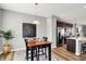 Open dining area features a dark wood table, modern lighting, stainless steel appliances and island with bar stool at 3046 W New York St, Indianapolis, IN 46222
