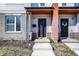The townhouse entrance features a covered porch, modern black door, digital lock and exterior light at 3046 W New York St, Indianapolis, IN 46222
