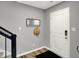 The foyer offers modern gray walls, a white front door, dark floors and a coat rack with mirror at 3046 W New York St, Indianapolis, IN 46222