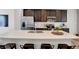 Modern kitchen with stainless steel appliances, a large island with breakfast bar, and stylish dark wood cabinets at 3046 W New York St, Indianapolis, IN 46222