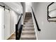 Carpeted stairway with dark wooden railing connects multiple floors and boasts natural light from nearby windows at 3046 W New York St, Indianapolis, IN 46222