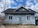 The back of this house exhibits weathered siding, framed windows, and a dark shingled roof at 3132 E 36Th St, Indianapolis, IN 46218