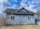 The back of this house features weathered siding, framed windows, and a dark shingled roof at 3132 E 36Th St, Indianapolis, IN 46218