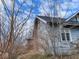 This home's exterior features weathered siding, a brick chimney, and mature trees at 3132 E 36Th St, Indianapolis, IN 46218