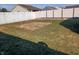 A spacious backyard enclosed by a white fence, showing both green grass and areas needing some TLC at 3336 Fall Valley Dr, Columbus, IN 47203