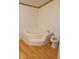 Corner bathtub, with a toilet, inside a compact bathroom at 3336 Fall Valley Dr, Columbus, IN 47203