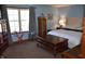 Serene main bedroom showcasing wood furniture, ample natural light, and a comfortable king-size bed at 3546 Stierwalt Rd, Quincy, IN 47456