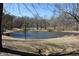 A tranquil pond surrounded by trees on a sunny day at 3546 Stierwalt Rd, Quincy, IN 47456