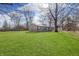 Cozy home with a large front yard, mature trees, and bright blue sky at 4159 N Ridgeview Dr, Indianapolis, IN 46226