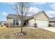 Well-kept single-story home with a two-car garage, light siding, and a neat front yard landscape at 4829 Penoyer Ln, Indianapolis, IN 46235