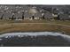 Aerial view of single-Gathering homes that back up to a walking path around a pond with a partially frozen surface at 488 Ehrlich Ln, Westfield, IN 46069