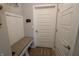 Mud room with white bench seat and storage, white doors and wood-look flooring at 488 Ehrlich Ln, Westfield, IN 46069