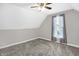 Bedroom features a modern ceiling fan, window, and neutral gray walls and carpet at 505 W Washington St, Shelbyville, IN 46176
