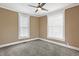 Comfortable bedroom with plush carpet, ceiling fan, and windows for natural light at 505 W Washington St, Shelbyville, IN 46176