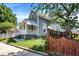A quaint home with gray siding, a striped awning, a wooden fence and lush landscaping at 505 W Washington St, Shelbyville, IN 46176