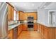View of kitchen features stainless steel oven, microwave, wood cabinets and flooring at 505 W Washington St, Shelbyville, IN 46176