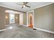 Open living room featuring plush carpet, ceiling fan, and great natural light from the windows at 505 W Washington St, Shelbyville, IN 46176