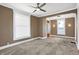Inviting living room featuring plush carpet, ceiling fan, and natural light at 505 W Washington St, Shelbyville, IN 46176