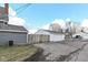 Detached two-car garage with white siding and a weathered wooden fence at 516 W Washington St, Lebanon, IN 46052