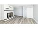 Bright living room with a painted brick fireplace, gray floors, and sliding closet door at 516 W Washington St, Lebanon, IN 46052