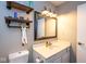 Bathroom with cute floating shelves, a toilet, a white vanity, and a large mirror at 5629 Crittenden Ave, Indianapolis, IN 46220
