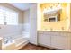 Inviting bathroom features a large tub, white cabinets, and an inset mirror over a white vanity at 5629 Crittenden Ave, Indianapolis, IN 46220