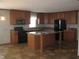Well-equipped kitchen with stainless steel appliances, wooden cabinetry, and a center island at 5820 N Nebo Rd, Muncie, IN 47304