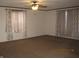 Cozy living room featuring neutral decor, carpeted floors, large windows, and a ceiling fan at 5820 N Nebo Rd, Muncie, IN 47304
