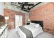 Modern bedroom featuring exposed brick walls, a ceiling fan, and a comfortable queen bed at 735 Lexington Ave # 30, Indianapolis, IN 46203