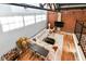 Living room features exposed brick, wood floors, modern sectional sofa, and a large television at 735 Lexington Ave # 30, Indianapolis, IN 46203