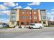 Exterior view of newly built condominiums featuring mixed brick and siding, situated near street parking and blue skies at 76 E Wayne St # B, Franklin, IN 46131