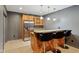Finished basement bar area with stainless steel fridge, wooden cabinets, and bar seating at 8015 Sargent Rdg, Indianapolis, IN 46256