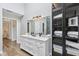 Bright bathroom with double vanity, large mirror, cabinet and tiled glass-enclosed shower at 8015 Sargent Rdg, Indianapolis, IN 46256
