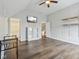 Spacious bedroom featuring wood floors, ceiling fan, mounted TV, and ample storage space at 8015 Sargent Rdg, Indianapolis, IN 46256
