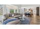 Open-concept living area with large windows, modern furniture, and a seamless flow to the kitchen at 8015 Sargent Rdg, Indianapolis, IN 46256