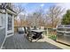 Outdoor patio featuring a stainless steel grill, dining table with umbrella, and wooded views at 8015 Sargent Rdg, Indianapolis, IN 46256