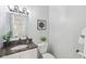 Cozy powder room with modern fixtures, dark countertops, and a decorative mirror at 8015 Sargent Rdg, Indianapolis, IN 46256