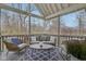 Relax on this screened porch featuring a comfortable seating area and views of the surrounding trees at 8015 Sargent Rdg, Indianapolis, IN 46256