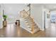 Carpeted staircase with white wood banisters leads to the upper level, with wood floors in the foyer at 8015 Sargent Rdg, Indianapolis, IN 46256