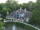 Stunning aerial view of a blue house with lush landscaping and a serene water feature at 8061 Lower Bay Ln # 1, Indianapolis, IN 46236