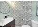 Modern bathroom featuring tiled walls, vessel sink, round mirror, and sleek toilet at 8061 Lower Bay Ln # 1, Indianapolis, IN 46236