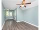 Bright bedroom features a ceiling fan, wood-look floors, two windows, and light blue walls at 8061 Lower Bay Ln # 1, Indianapolis, IN 46236