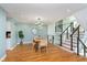 Bright dining room with sleek wooden table and chairs, open stairwell, modern lighting, and adjacent kitchen at 8061 Lower Bay Ln # 1, Indianapolis, IN 46236