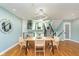 Bright dining room featuring modern light fixture, sleek wooden table and modern chairs, and open stairwell at 8061 Lower Bay Ln # 1, Indianapolis, IN 46236
