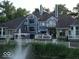Beautiful backyard view of a blue house with a gazebo and waterfront fountain at 8061 Lower Bay Ln # 1, Indianapolis, IN 46236