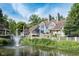 Lovely backyard view of a blue house with a gazebo and waterfront fountain at 8061 Lower Bay Ln # 1, Indianapolis, IN 46236