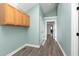 Hallway with wood-look floors, cabinet storage, and access to additional rooms at 8061 Lower Bay Ln # 1, Indianapolis, IN 46236